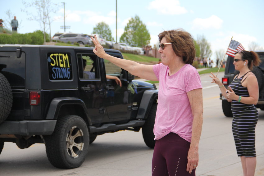 Bonnie Alexander, 68, waves a peace sign at drivers in a motorcade of more than 200 Jeeps and some other vehicles toward a May 15 memorial service for Kendrick Castillo. Castillo “was an angel in our midst,” said Alexander, a Highlands Ranch resident.